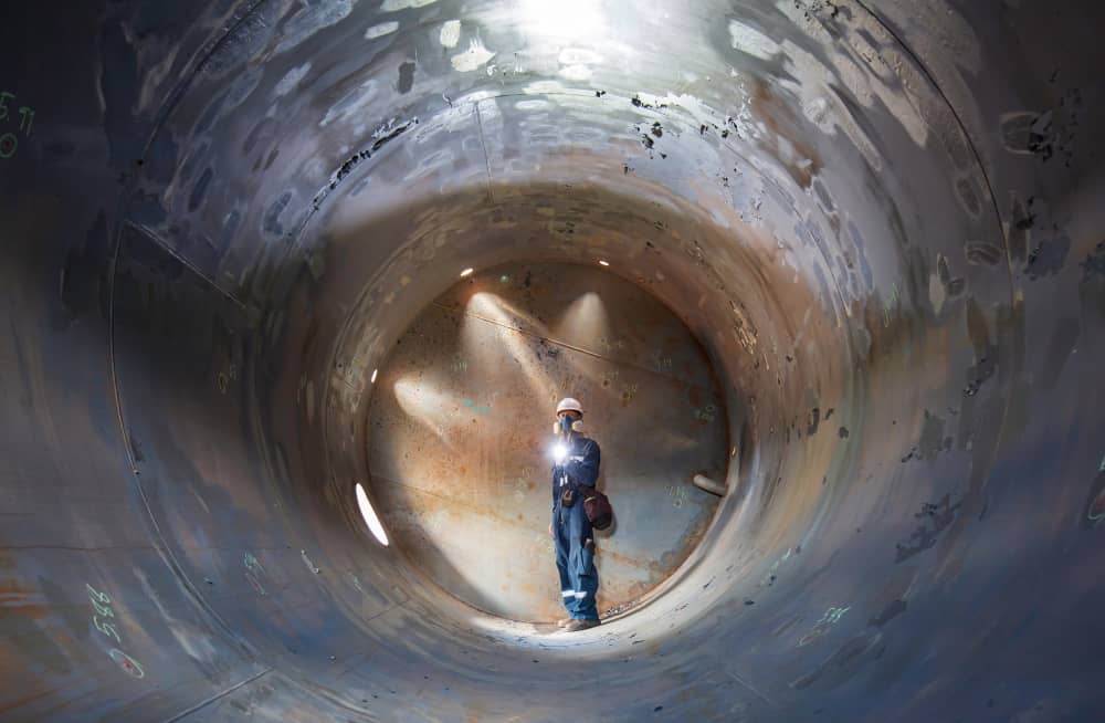 Worker checking underground tunnel.